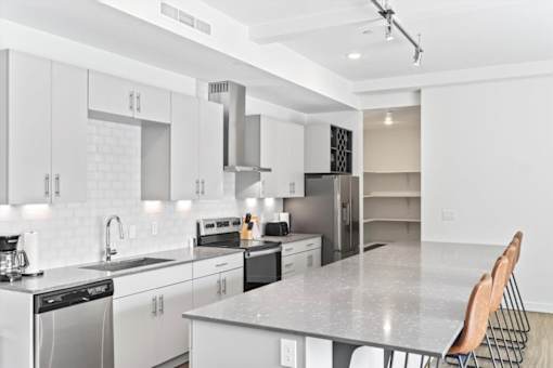 A modern kitchen with white cabinets and appliances.
