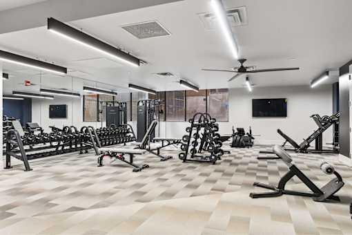 A spacious gym with a variety of equipment and a checkered floor.