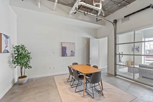 A room with a table and chairs and a plant.