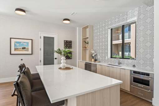A modern kitchen with a large island and a dining table.