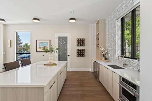 A modern kitchen with a white countertop and wooden cabinets.