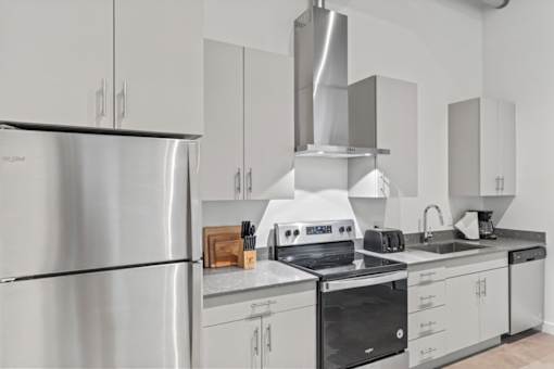 A modern kitchen with stainless steel appliances and white cabinets.