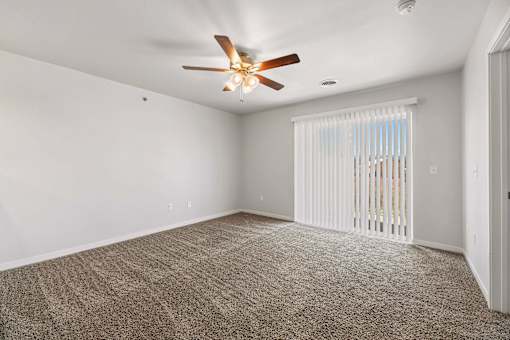 an empty living room with a ceiling fan and a window at Red Rock Apartments, Rapid City, SD