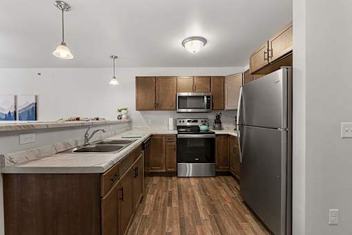 a kitchen with stainless steel appliances and wooden cabinets at Red Rock Apartments, Rapid City, 57702