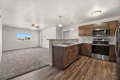 a kitchen with wooden cabinets and stainless steel appliances at Red Rock Apartments, Rapid City, SD, 57702
