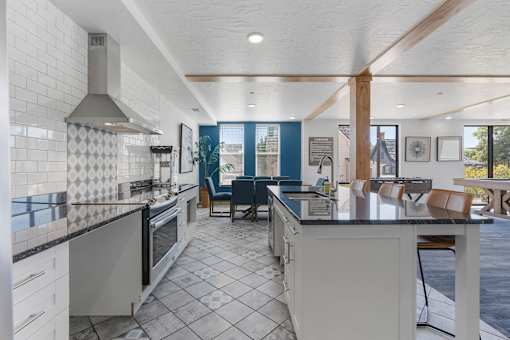 a kitchen with an island and a dining room with a table and chairs at City View St. George Apartments, Utah