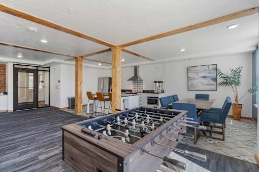 a family room with a foosball table and a kitchen with a dining area at City View St. George Apartments, St George