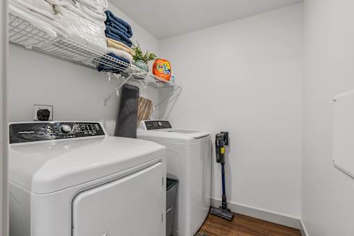 a washer and dryer in a small laundry room with white walls and wood at City View St. George Apartments, St George, Utah