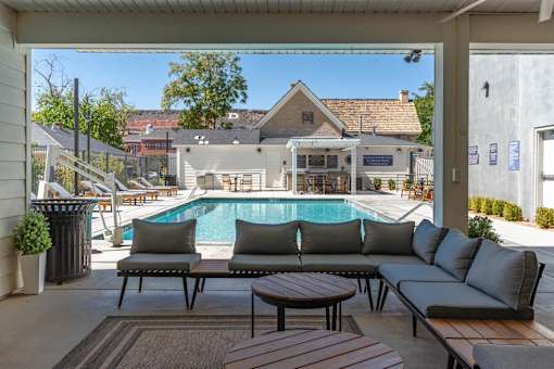 a swimming pool is seen from a patio with couches and tables at City View St. George Apartments, Utah, 84770