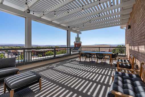 a covered patio with a table and chairs and a view of the city at City View St. George Apartments, St George, Utah