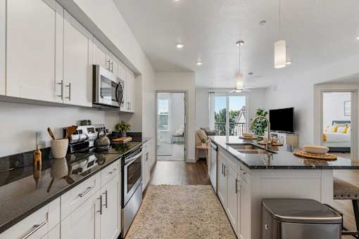 an open kitchen with white cabinets and a large counter top at City View St. George Apartments, Utah, 84770