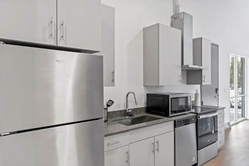 A modern kitchen with stainless steel appliances and white cabinets.