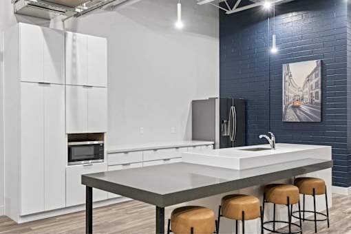 A modern kitchen with white cabinets and a grey countertop.