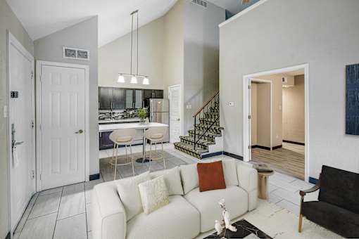 A living room with a white couch and a black chair.