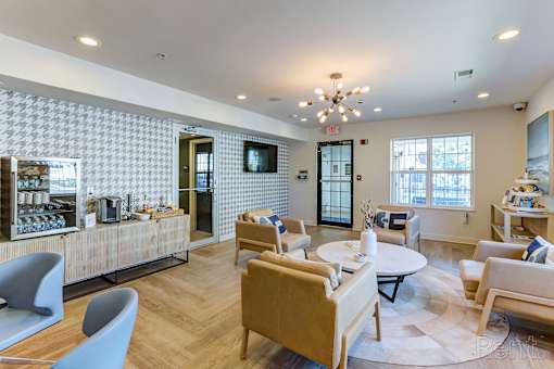 A modern living room with a patterned wallpaper and a variety of seating options.
