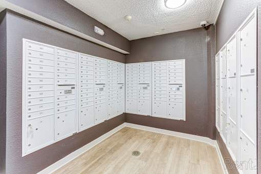 A room with a wall of lockers and a list of names on the wall.