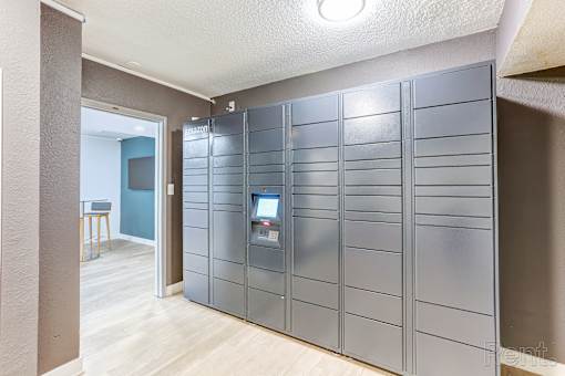 A room with a grey wall and a grey locker with a computer on it.