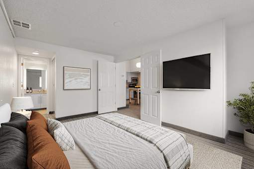 A bedroom with a large bed and a flat screen TV mounted on the wall.