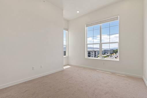 A large empty room with a window overlooking a cityscape.