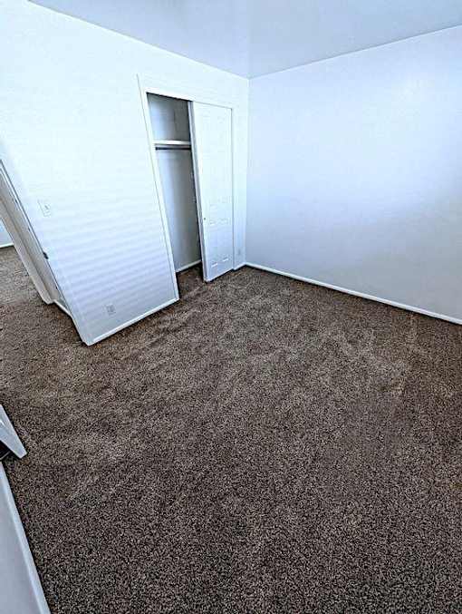A room with a carpeted floor and a white wall.