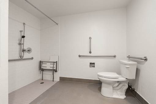 A white toilet in a small bathroom with a towel rack and a towel bar at AVIA Lofts on Parkway Apartments, Vancouver, WA