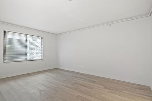 the living room of an empty home with white walls and a window at AVIA Lofts on Liberty Ridge, Jacksonville, FL, 32256