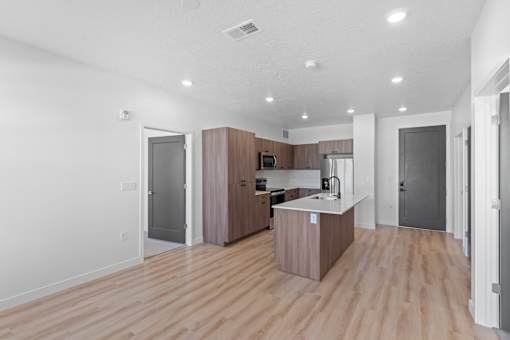 A kitchen with wooden floors and a white counter.