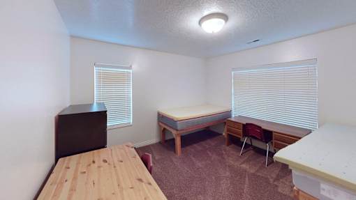 A room with a bed, a table, and a chair.