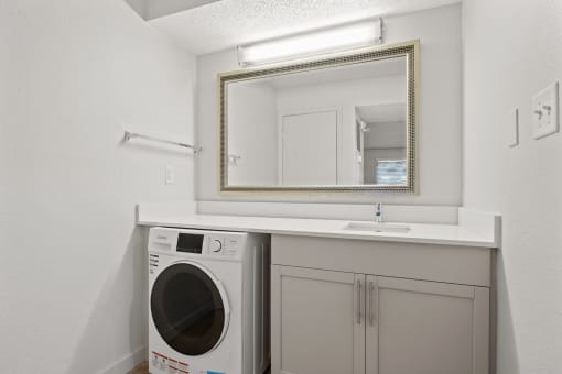 a white laundry room with a sink and a washing machine at AVIA Lofts on Liberty Ridge, Jacksonville, FL