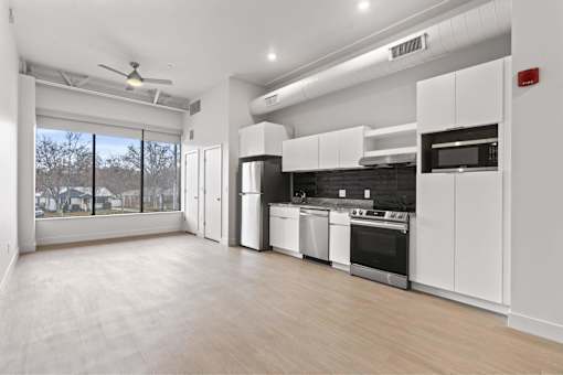 A spacious kitchen with white cabinets and stainless steel appliances.