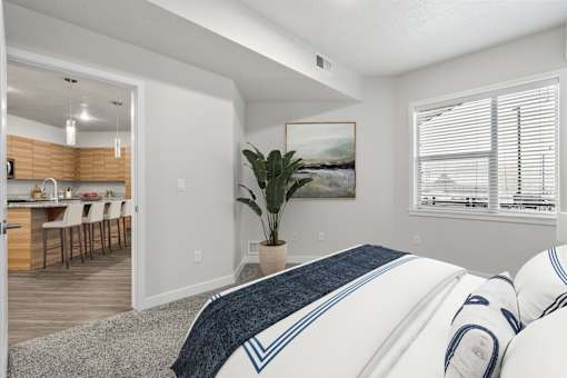 A bedroom with a large bed and a painting on the wall.