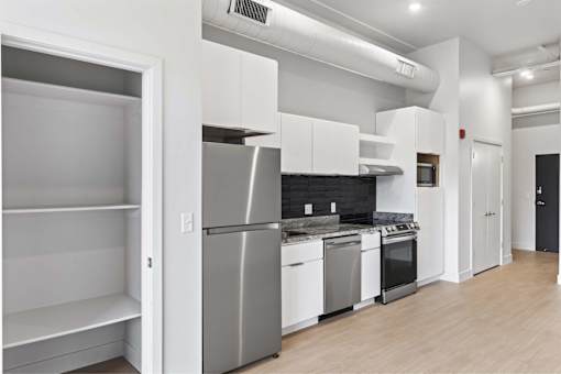 A kitchen with white appliances and cabinets.