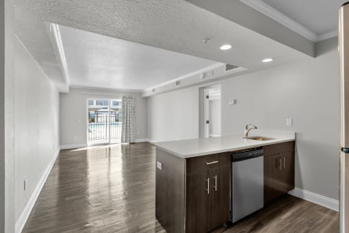 the living room and kitchen in a new home with white walls and wood floors