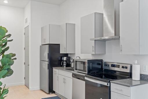 A modern kitchen with a black refrigerator and stove.