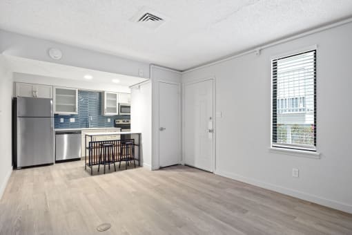 the living room and kitchen of an apartment with a crib and a refrigerator at AVIA Lofts on Liberty Ridge, Florida, 32256