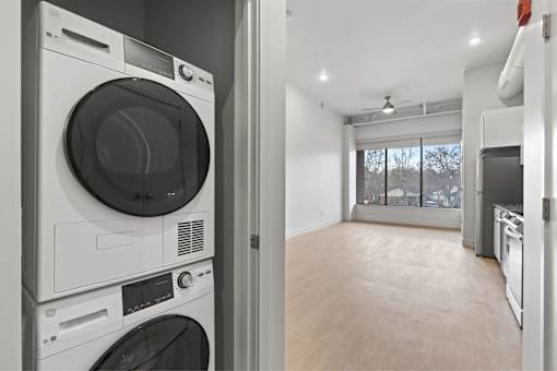 A modern laundry room with a washer and dryer stacked on top of each other.