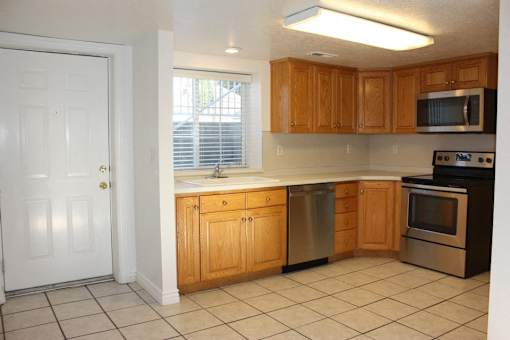 A kitchen with wooden cabinets and a white door.