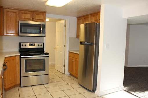 A kitchen with a stove, microwave, and refrigerator.