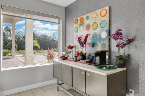 a kitchen with a large painting on the wall next to a window