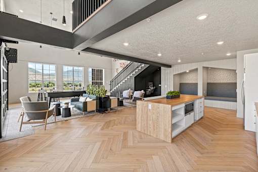 A modern open plan living and kitchen area with wooden flooring.