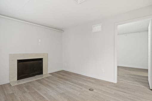 the living room of an apartment with a fireplace and wooden floors at AVIA Lofts on Liberty Ridge, Jacksonville, FL