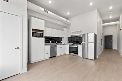 A modern kitchen with white cabinets and stainless steel appliances.