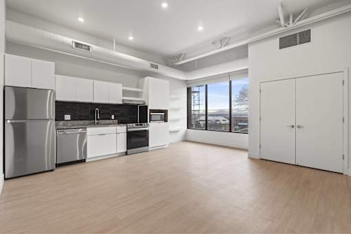 A modern kitchen with stainless steel appliances and white cabinetry.