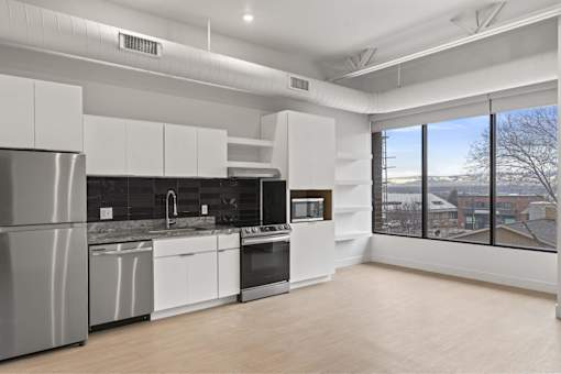 A modern kitchen with white cabinets and stainless steel appliances.