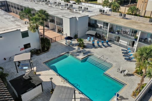 an aerial view of a swimming pool in front of a building