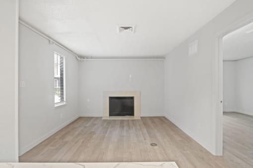 an empty living room with a fireplace and wooden floors at AVIA Lofts on Liberty Ridge, Florida
