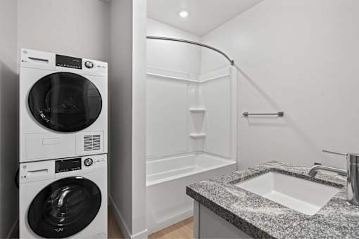 A modern laundry room with a washer and dryer stacked on top of each other.
