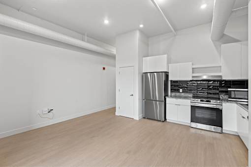 A modern kitchen with white cabinets and stainless steel appliances.
