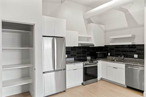 A modern kitchen with stainless steel appliances and white cabinetry.