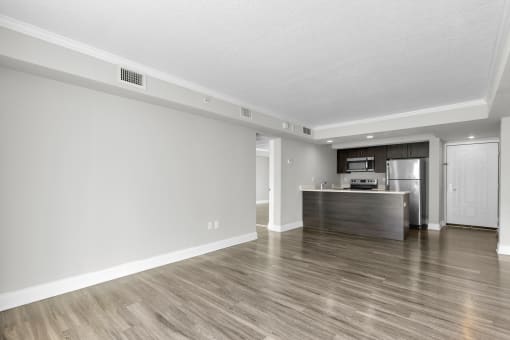 the spacious living room and kitchen in a new home